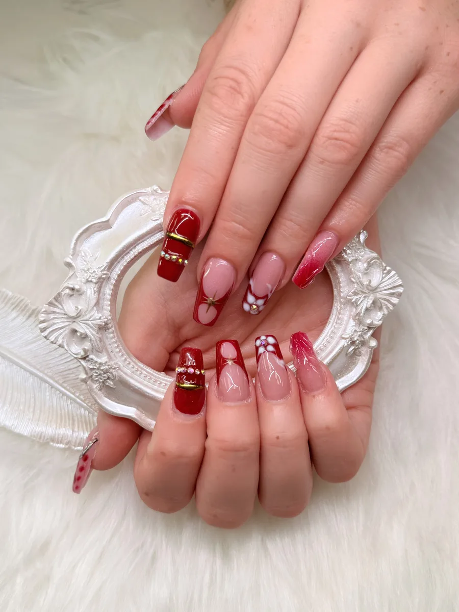 Red and blush statement nail art with gold accents