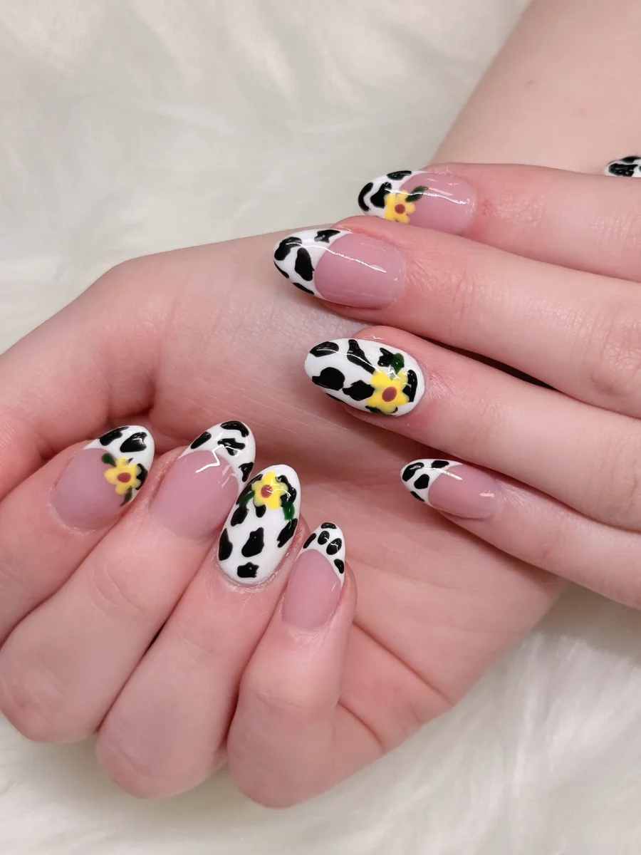 Cow-print French nails with yellow floral details